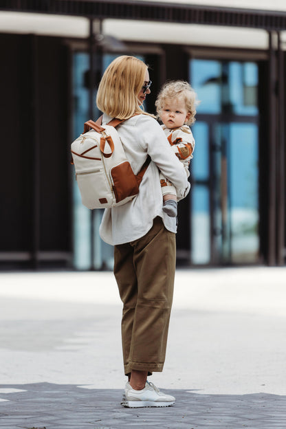 Mother walking outdoors with the lightweight Small Cappuccino Backpack