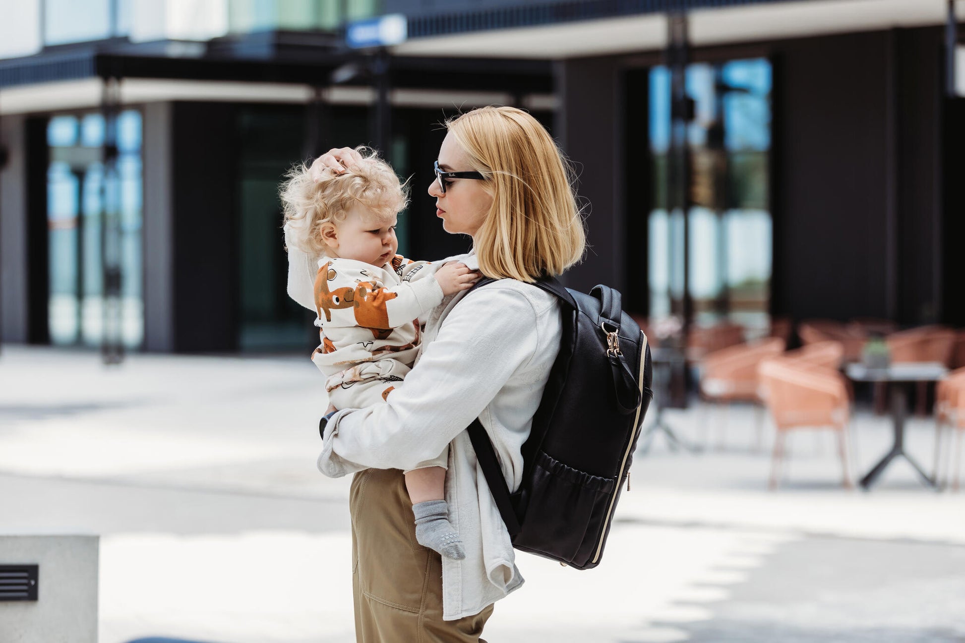 Parent walking outdoors with the Large Espresso Backpack for a weekend trip