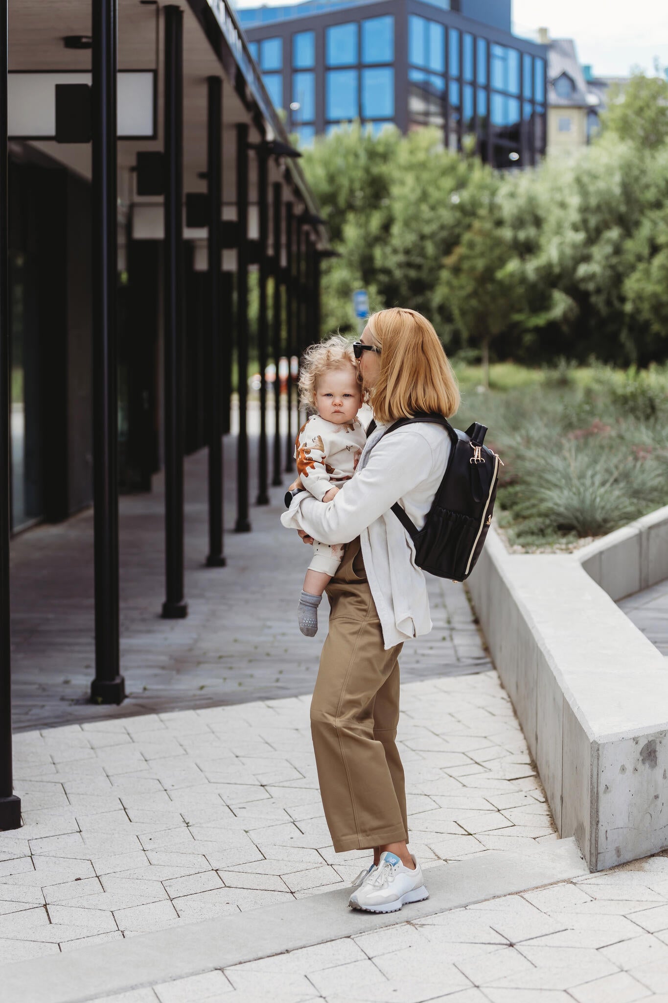 Mother walking outdoors with the lightweight Small Espresso Backpack