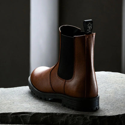 Brown leather boot with a visible brand logo on a gray surface.