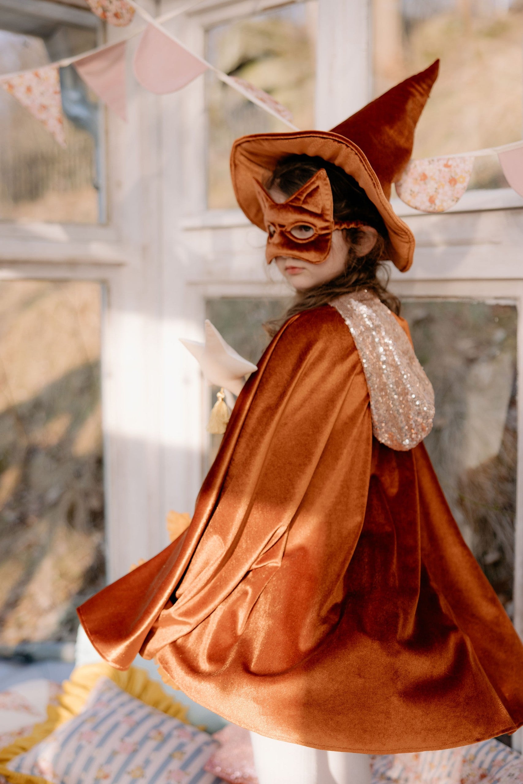 Lifestyle: Little girl wearing the Ginger Magic Cape in a cosy room