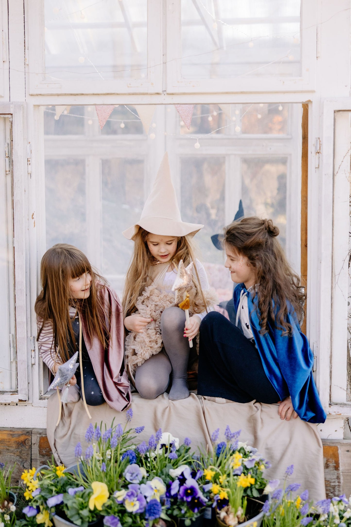 Pretend play scene: Toddler in a Rose Gold cat costume near a crib