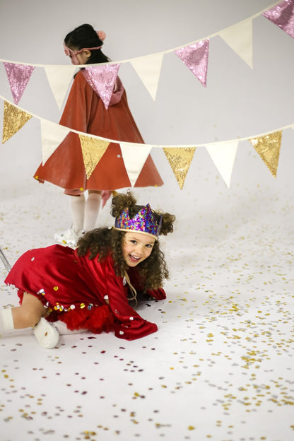 Party time: joyful children playing and laughing under a shimmering gold and beige Sequin Garland Pink and Beigin a bright nursery