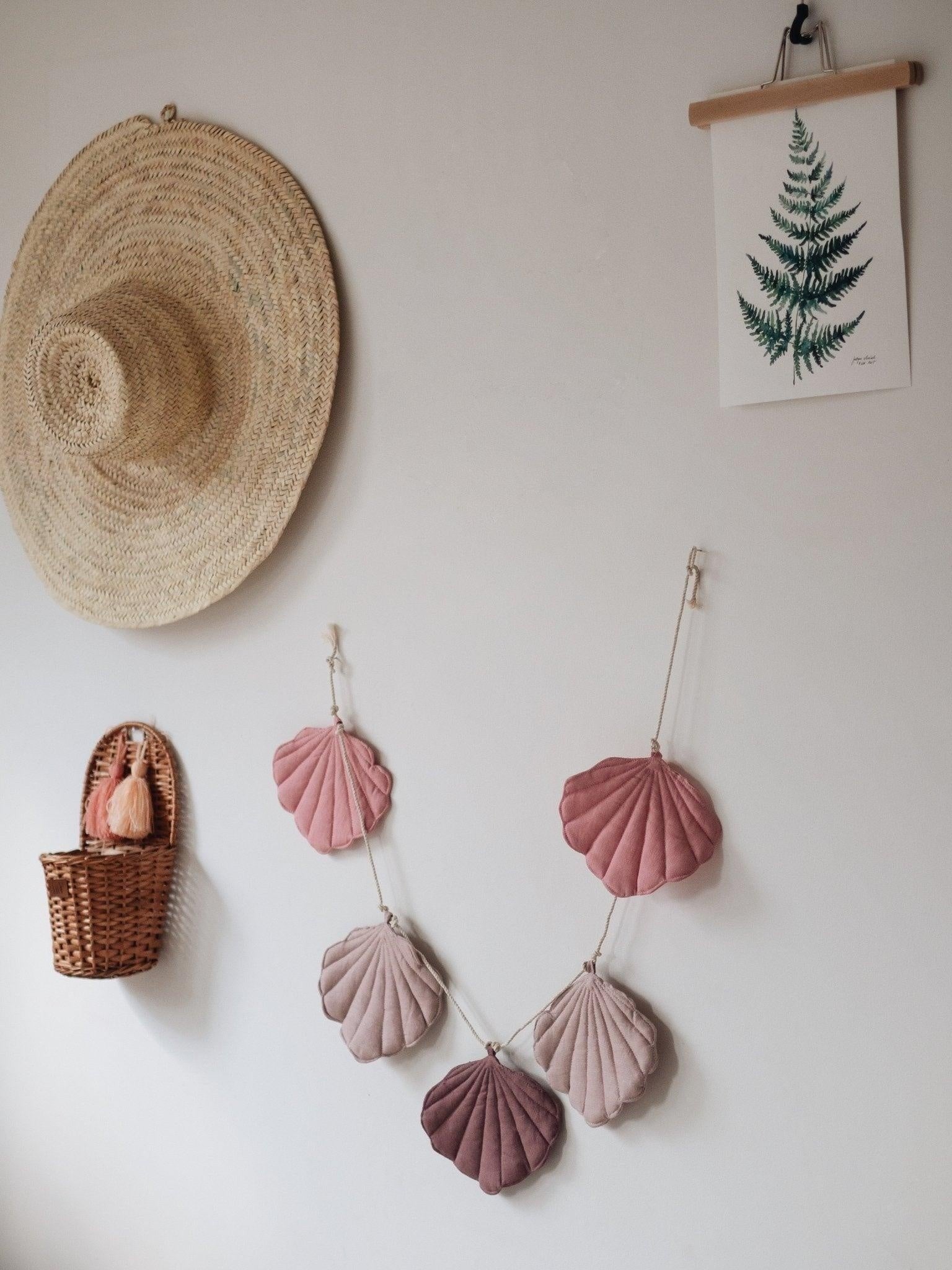 Modern powder pink shell garland hanging in a bright, dreamy nursery