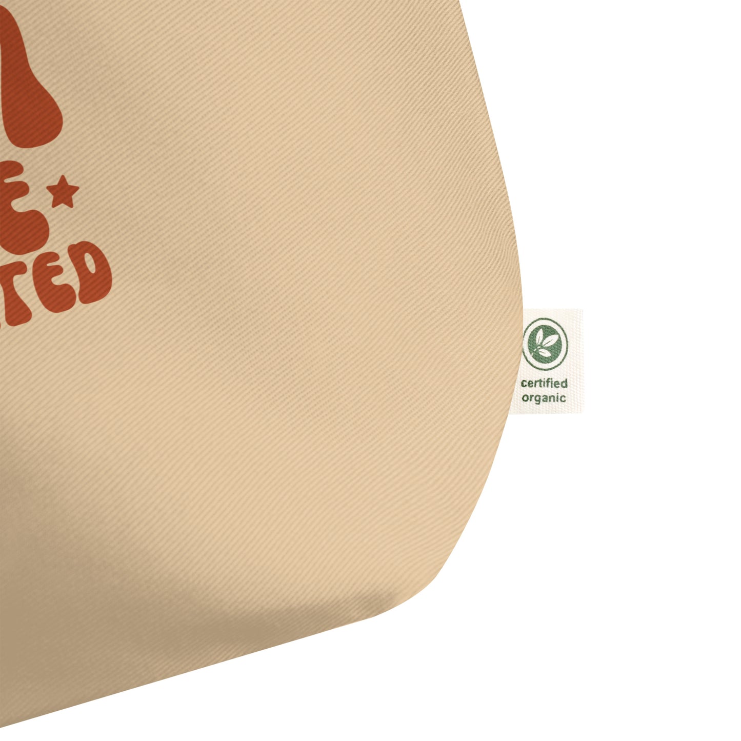 Extreme close-up of the 8 oz heavy-duty cotton twill fabric texture, featuring the sewn-in 'Certified Organic Cotton' label.