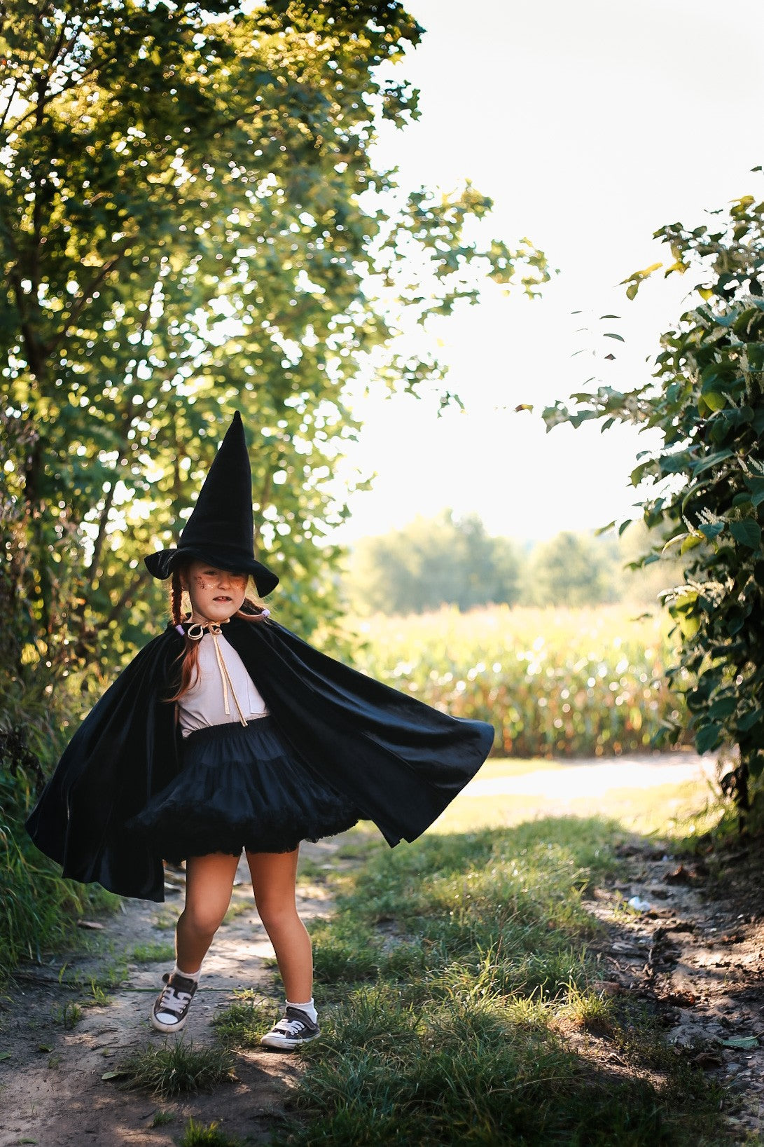 Outdoor pretend play: Black cape flowing in the wind by ancient trees