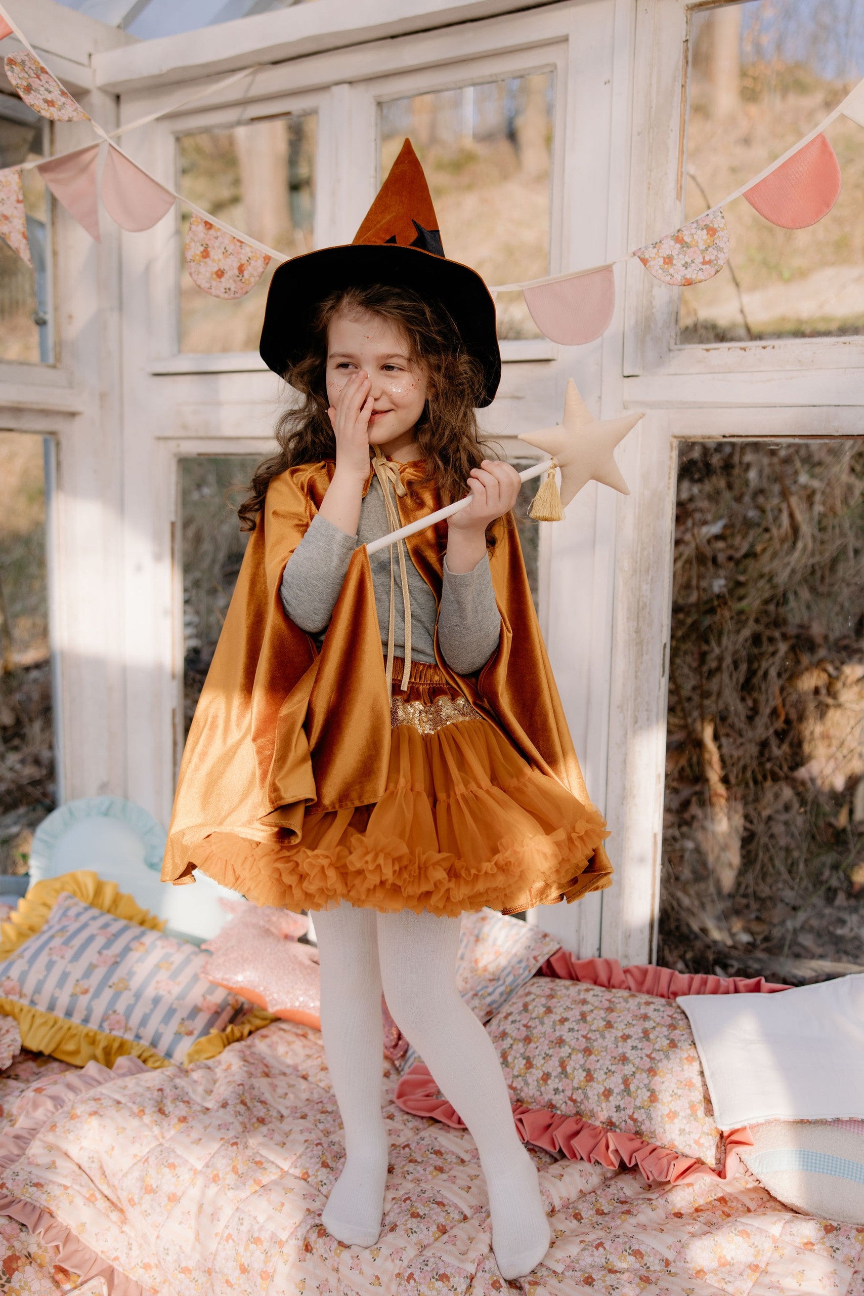 Magical play scene: child in Golden Riding Hood shimmering cape in a Montessori playroom