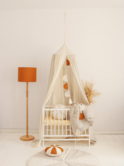 Nursery decor: Cream Circus canopy creating a bright magic tent over a white baby crib