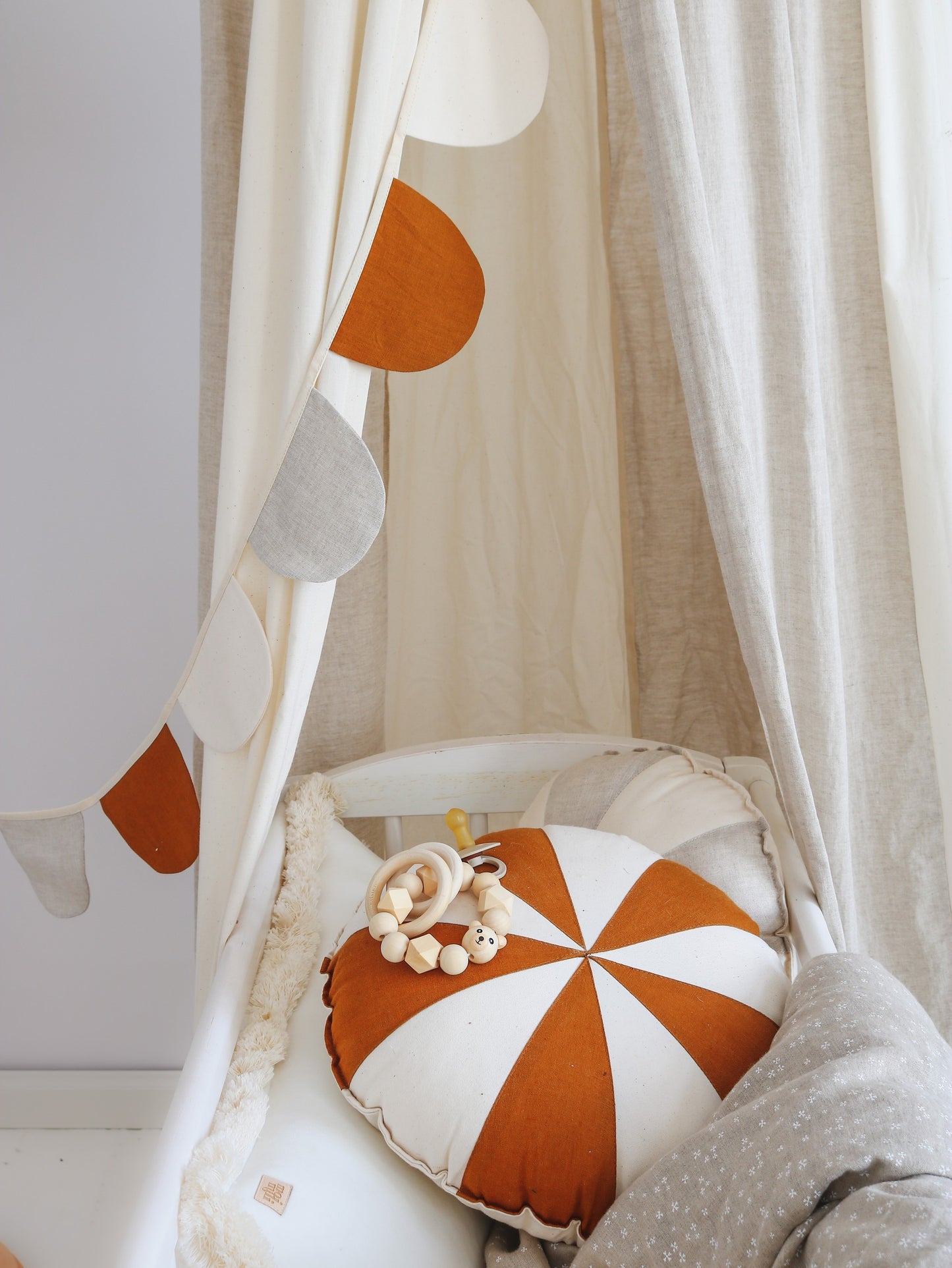Minimalist kids room: Cream Circus organic cotton canopy styled with natural wood furniture