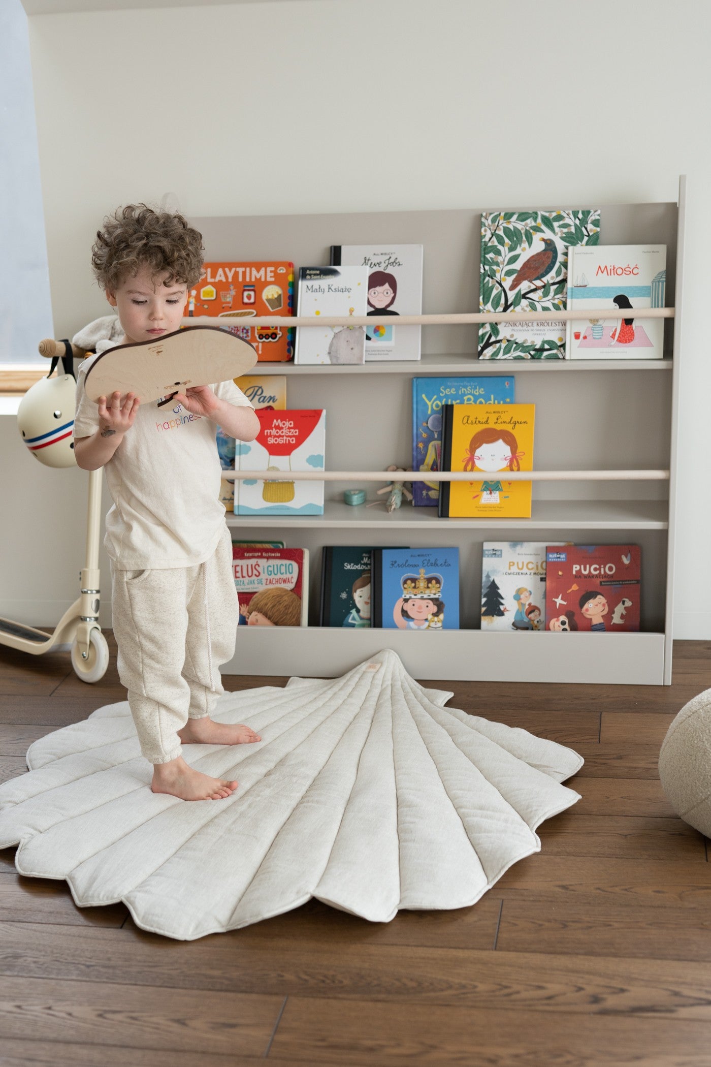 Cosy scene: a baby playing with wooden toys on the soft Sand linen mat