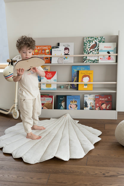 Cosy scene: a baby playing with wooden toys on the soft Sand linen mat