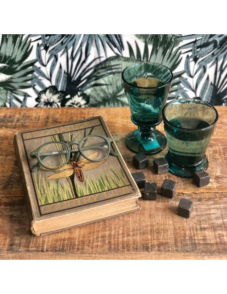 Cozy lifestyle scene with La Rochere Bee glasses and a book resting on a rustic raw wooden board