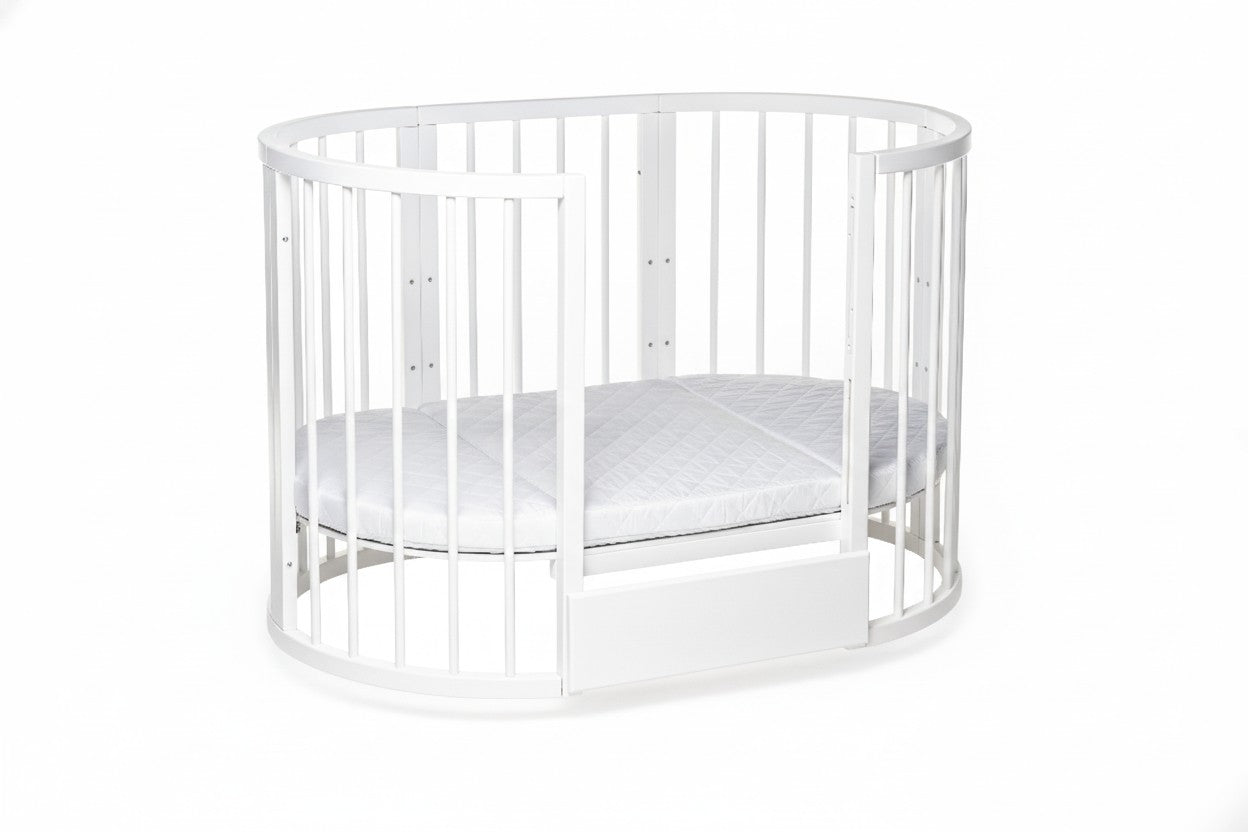 Detail of the curved wooden rails on the white KOTTO transforming crib