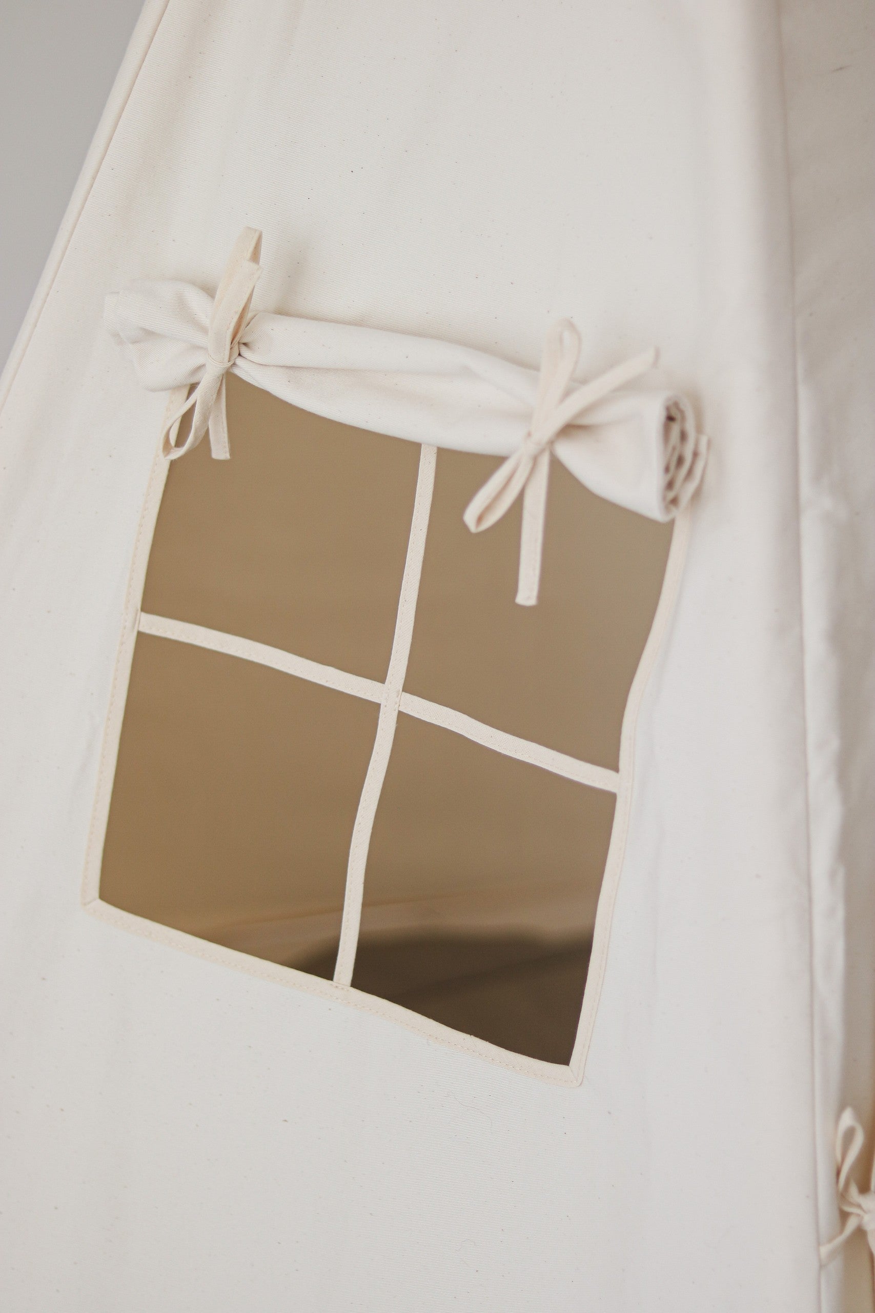 Nursery detail: close-up of the charming side window with roll-up curtain on a Moi Mili Beige Teepee Tent