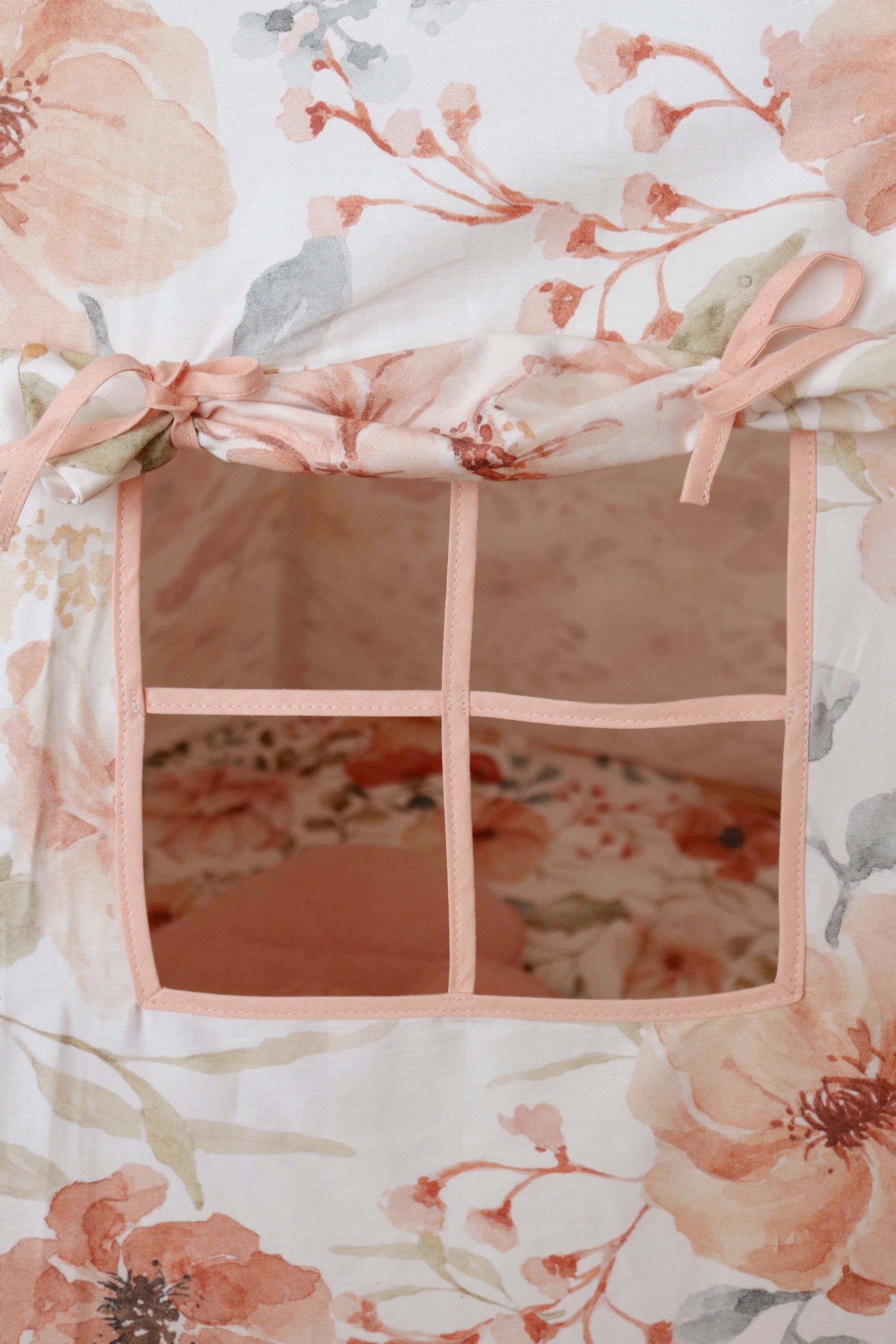 Nursery detail: close-up of the charming side window on a Moi Mili Flower Power Teepee Tent, featuring a vibrant vintage floral print