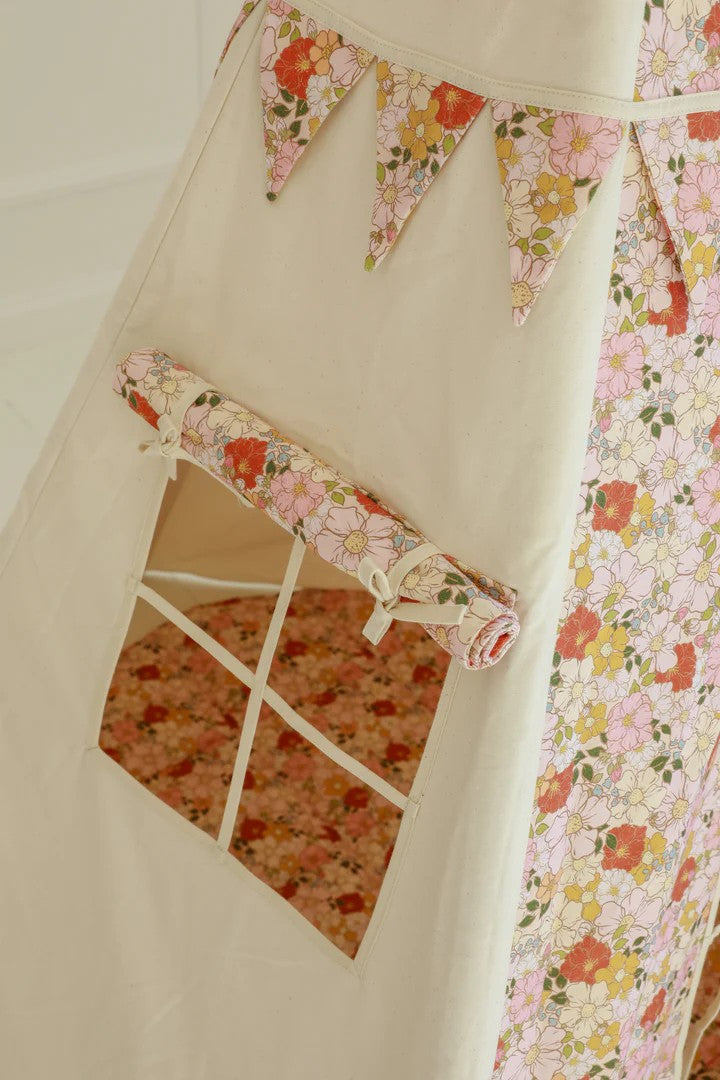 Nursery detail: close-up of the charming side window on a Moi Mili Spring Garden Teepee Tent, featuring a delicate spring flower print on white canvas