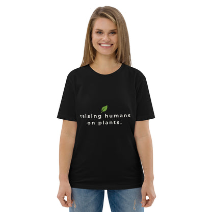 Frontal shot of a model in a black premium cotton tee displaying a vegan parenting message in crisp, contrasting text.