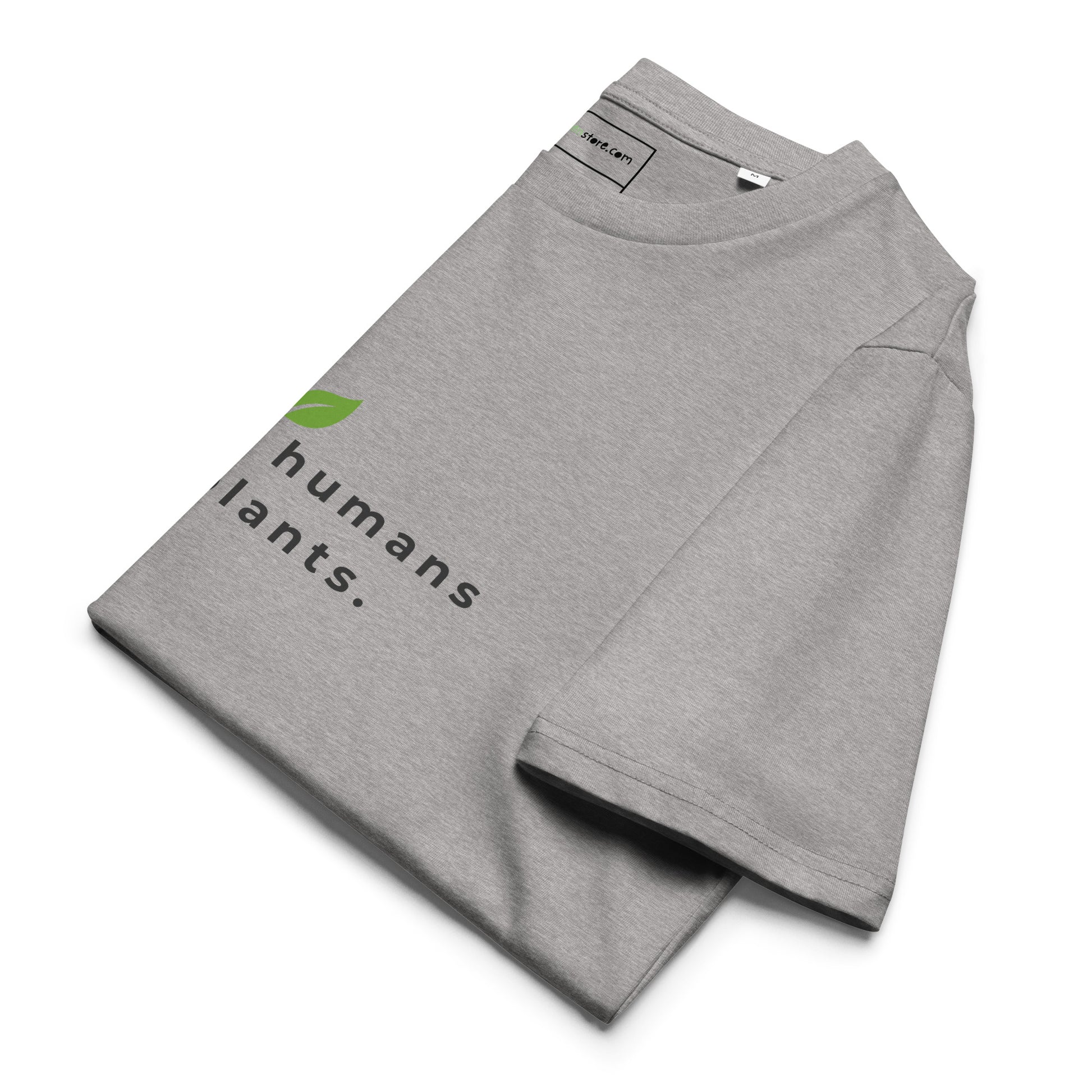 Sustainable t-shirt neatly folded on a flat surface. The top of the folded fabric displays the leaf logo and the "raising humans on plants." message designed for plant-based parents. - grey-